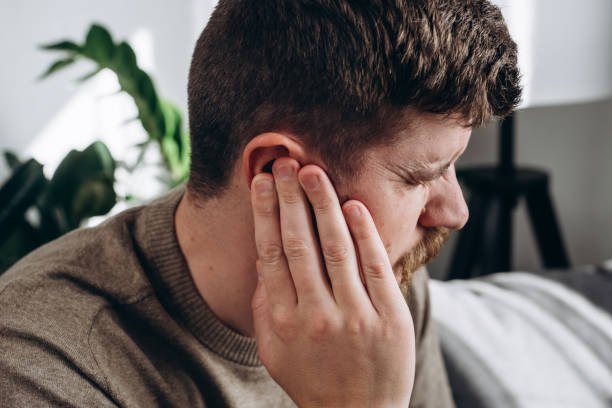 Man holding his ear due to chronic ear infection pain