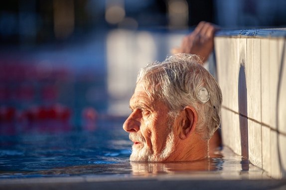 Man swimming while wearing a hearing implant