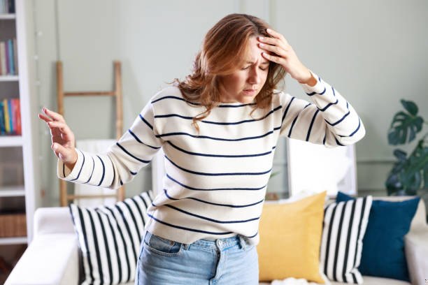 Woman experiencing dizziness and vertigo at home